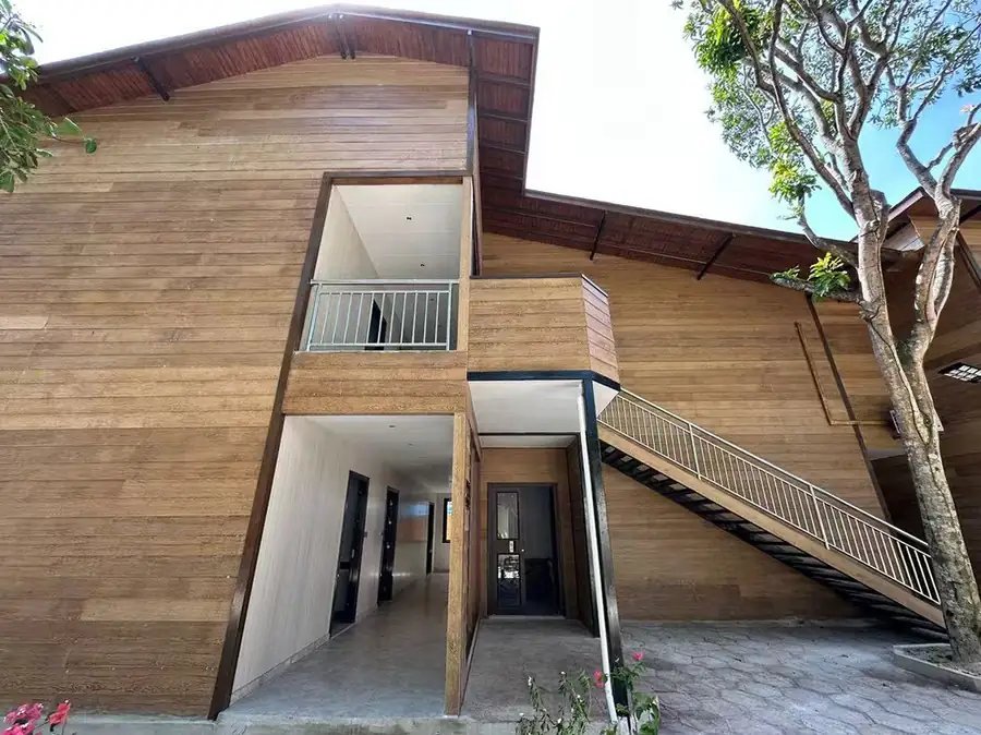 Two-storey timber-clad building with an outside staircase and a balcony, Doris Mataking Resort
