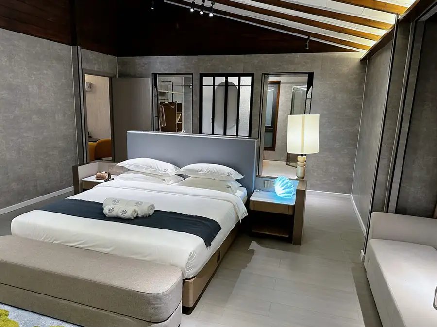 Bedroom with a large bed, grey walls, a bedside lamp and a dark timber ceiling, VIP Garden Suite, Doris Mataking Resort